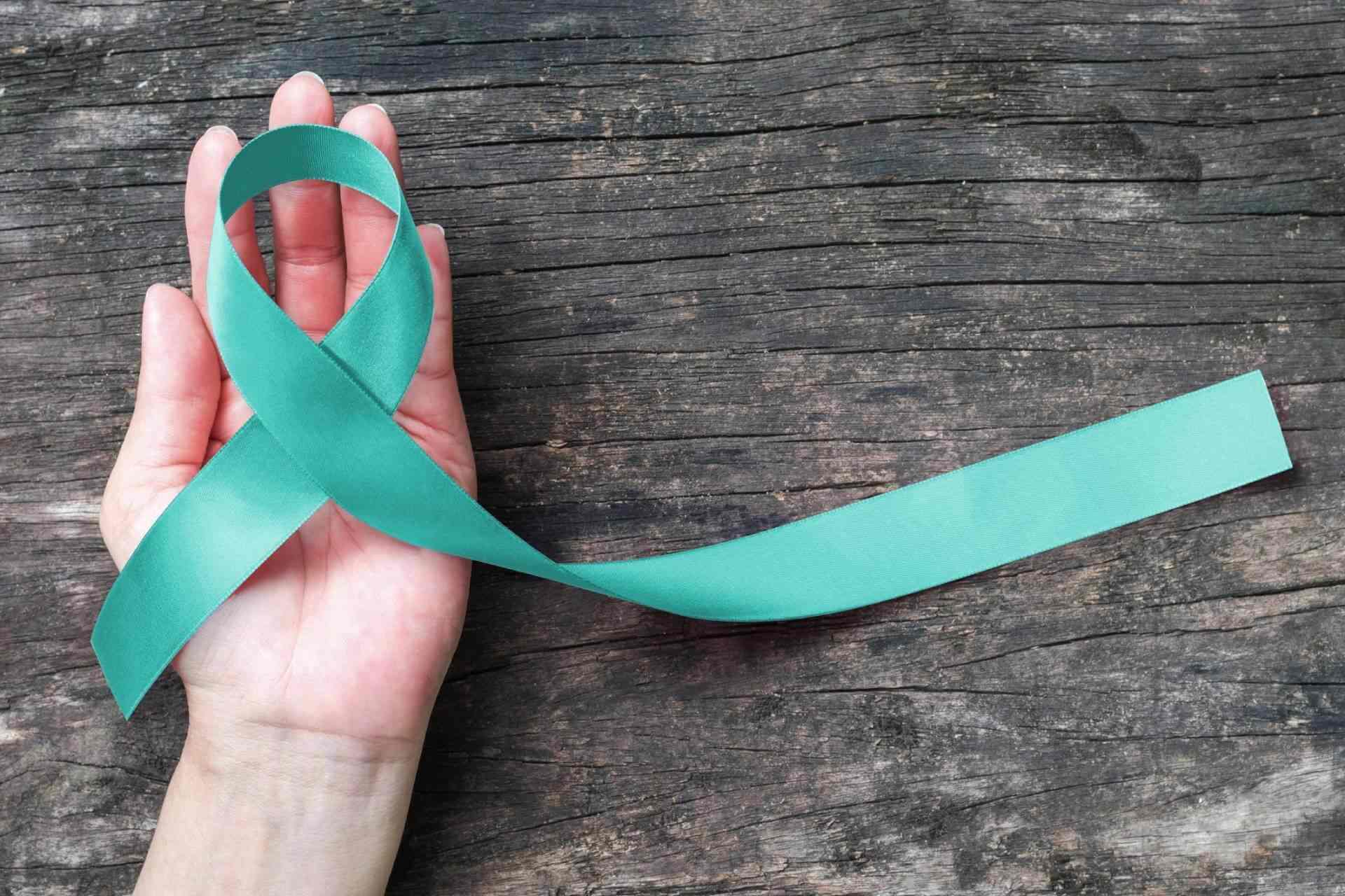kobieca dłoń z zieloną wstążką - profilaktyka raka szyjki macicy